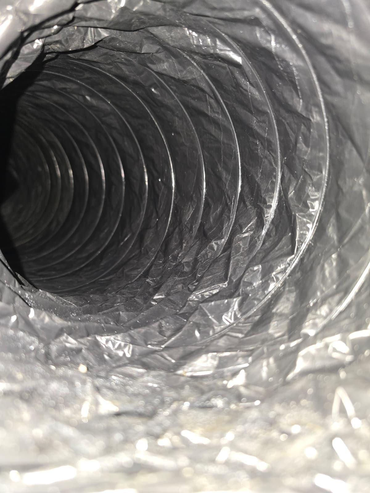 The inside of a flexible duct: a glossy black sleeve spiralling into the distance over its wire helix